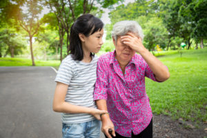 elderly woman lightheaded and young woman helping her