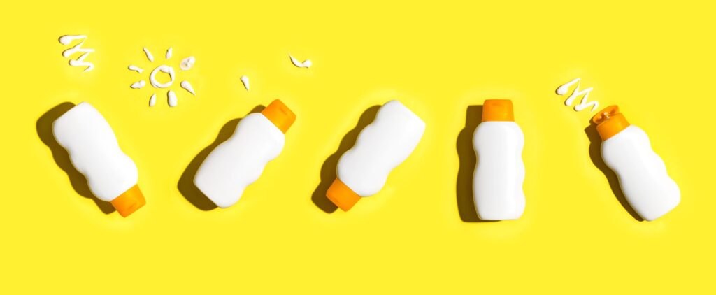 5 bottles of sunscreen with yellow background