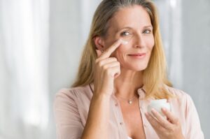 Woman applying cream for wrinkles